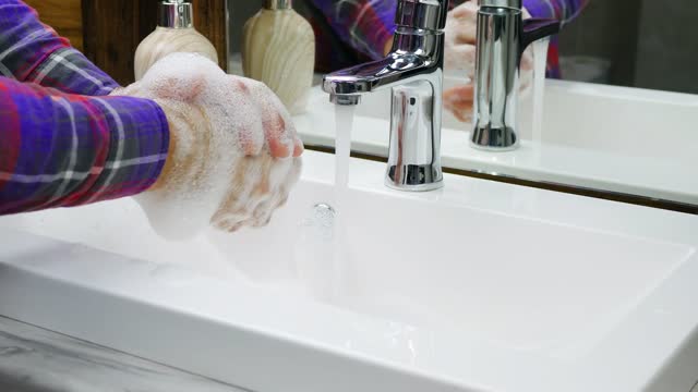 Wash-hands-under-a-tap-with-water,a-person-very-carefully-protects-himself-from-the-COVID-19-virus,wash-his-hands-in-foam,wash-off-dirt-from-his-hands,close-up