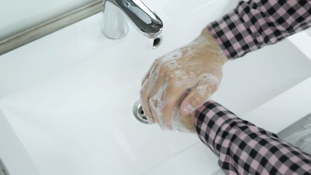 Young-man,a-man-washing-his-hands-under-a-tap-with-water,to-prevent-infection-with-coronavirus,close-up.To-wash-off-the-dirt-from-his-hands