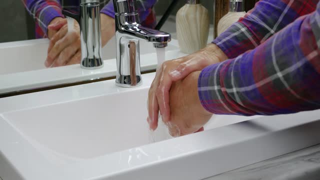 Hände-mit-Seife-unter-einem-Wasserhahn-waschen,-beobachtet-eine-Person,-wie-die-Körperhygiene-den-Schmutz-von-seinen-Händen-wegspült,-die-Vorbeugung-einer-Viruserkrankung,-die-Hände-spült.