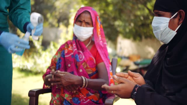 Médicos-médicos-al-aire-libre-con-una-mujer-de-la-tercera-edad-en-las-zonas-rurales-de-la-India