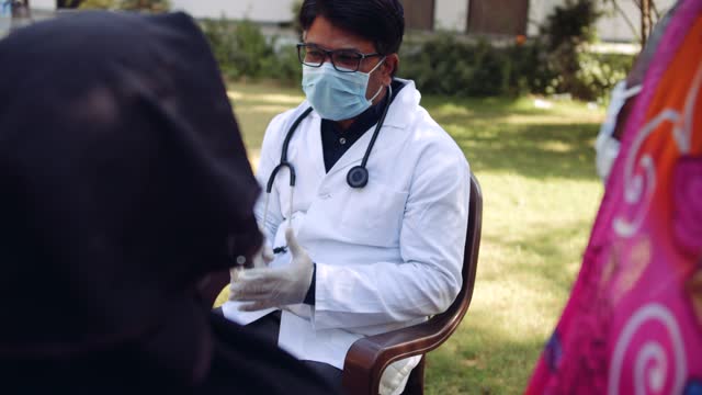 Ärzte-im-Freien-mit-einer-Seniorin-im-ländlichen-Indien