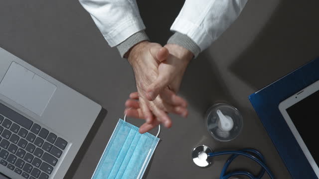 Arzt-auftragen-Desinfektionsmittel-auf-seine-Hände
