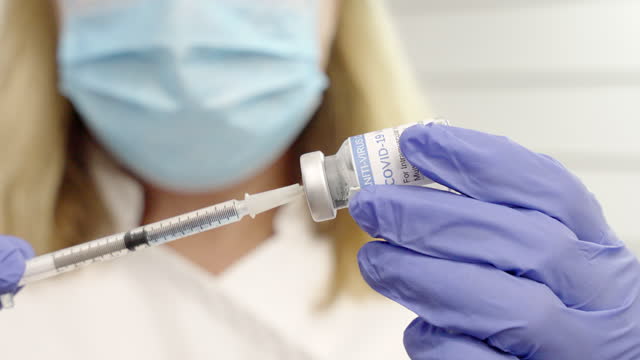 inyección-cercana-de-la-hembra-con-un-vial-de-coronavirus-y-jeringa