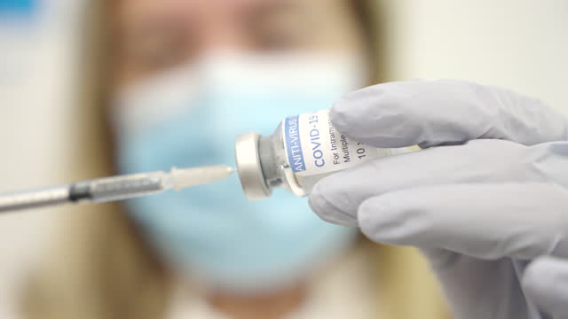 Nahaufnahme-einer-Mitarbeiterin-im-Gesundheitswesen,-die-eine-Spritze-mit-einem-Covid-19-Impfstoff-füllt