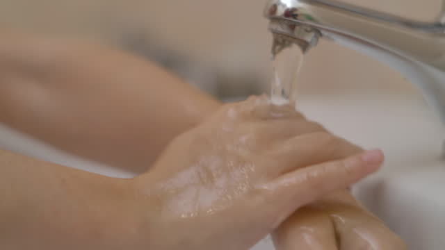 Kleines-Mädchen-waschen-Hände-mit-Seife-über-Waschbecken-im-Badezimmer.-Frau-waschen-Hände-reiben-mit-Seife.-Kind-für-Corona-Virus-Prävention,-Hygiene,-um-die-Verbreitung-Coronavirus-zu-stoppen.-Zeitlupe.