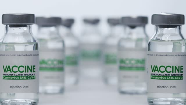 Las-botellas-de-la-vacuna-para-la-cura-del-coronavirus-COVID-19-se-encuentran-en-el-laboratorio-de-investigación-antes-de-la-inyección.-Vacunación,-ensayo-clínico-durante-la-pandemia.-Flacones,-viales.-Amplia-macro-slider-dolly-out-shot.-SARS-CoV-2.-Na