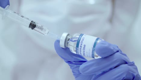 Close-up-hand-in-protective-glove-holding-vaccine-test,-Vaccine-injection,-drawn-up-vaccine-from-the-bottle-into-the-syringe,-vacine-covid19