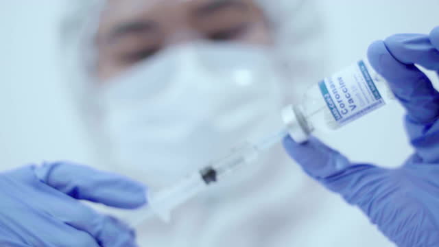 Close-up-hand-in-protective-glove-holding-vaccine-test,-Vaccine-injection,-drawn-up-vaccine-from-the-bottle-into-the-syringe,-vacine-covid19
