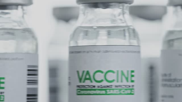 Looped.-Flacons-of-vaccine-for-COVID-19-coronavirus-cure-are-quickly-rotated-in-research-lab.-Vaccination,-injection,-clinical-trial-during-pandemic.-Bottles-are-spinning-clockwise.-Closeup-macro