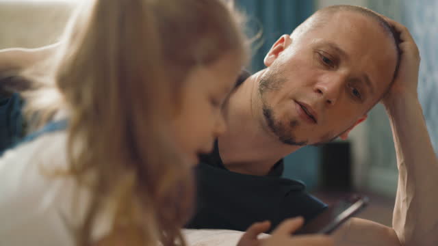 close-up-of-young-cute-dad-helps-little-daughter