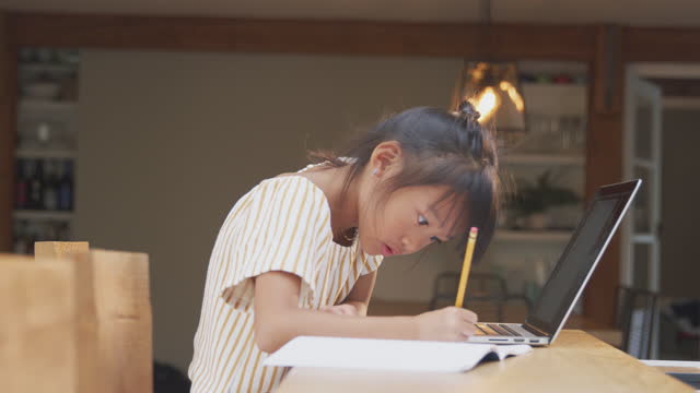 Junge-asiatische-Mädchen-zu-Hause-Schulbildung-am-Tisch-mit-Laptop-arbeiten