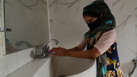 Maskierte-Mädchen-Waschen-Hände-mit-Seife-und-Wasser-und-mit-Alkohol-basierte-Hand-reiben-tötet-Viren.