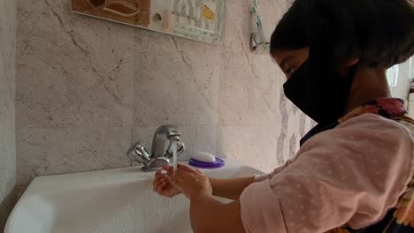 Masked-girl-Washing-hands-with-soap-and-water-and-using-alcohol-based-hand-rub-kills-viruses.