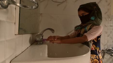 Masked-girl-Washing-hands-with-soap-and-water-and-using-alcohol-based-hand-rub-kills-viruses.