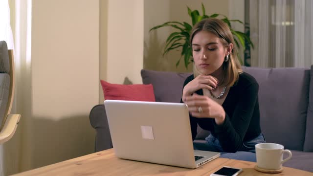 Türkische-junge-Frau-arbeiten-oder-studieren-zu-Hause-mit-einem-Computer-auf-dem-Tisch-mit-einer-Kaffeetasse