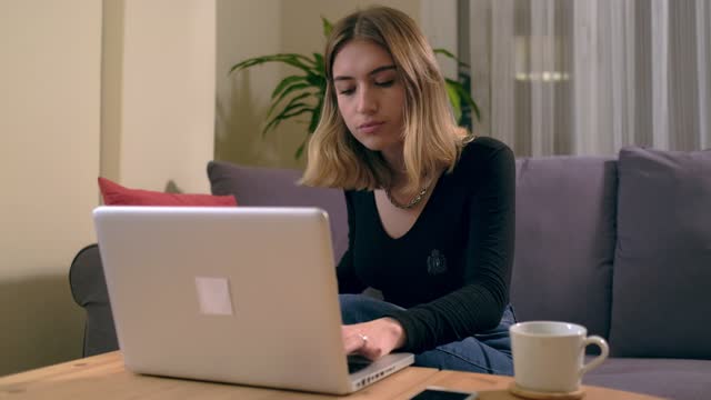 Turkish-young-woman-working-or-studying-at-home-with-a-computer-on-the-table-with-a-coffee-cup