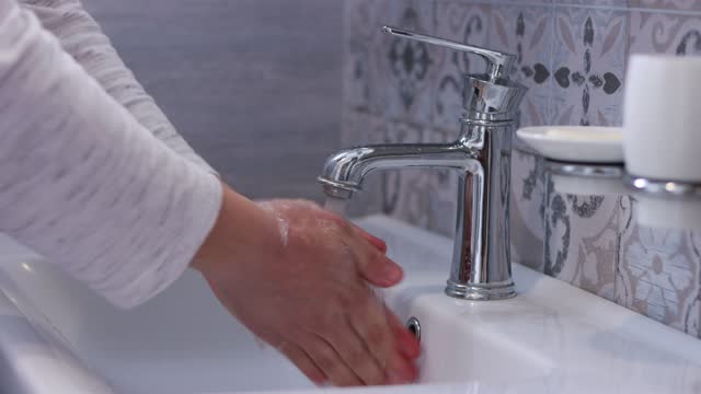 Man-washing-hands-in-the-bathroom