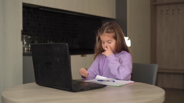 Kaukasische-Mädchen-studieren-online-über-das-Internet-auf-einem-Laptop-sitzen-zu-Hause-in-der-Küche.-beugt-seine-Finger,-um-zählen-zu-lernen.-Online-Lernkonzept