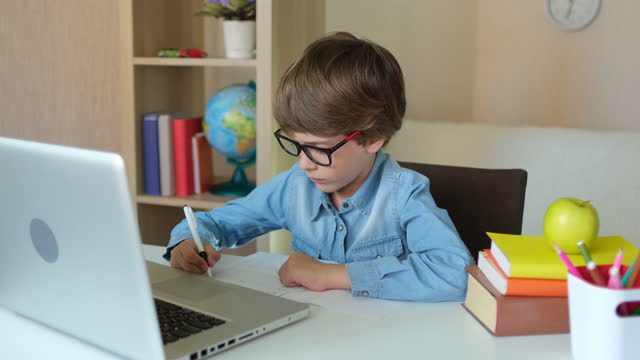 Kind-Junge-Kind-Schuljunge-in-Gläsern-mit-Tablet-Laptop-Computer-für-Schulhausaufgaben,-Lernen-zu-Hause