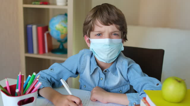 Kind-Little-Boy-Kid-Schuljunge-in-Schützenmedizin-Maske-lernen-Schreiben-Hausaufgaben-zu-Hause