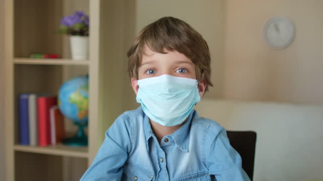 Portrait-of-Child-Boy-Kid-schoolboy-in-protective-medical-mask-looking-at-camera,-studying-at-home