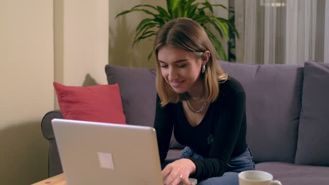 Joven-turca-trabajando-o-estudiando-en-casa-con-una-computadora-en-la-mesa-con-una-taza-de-café