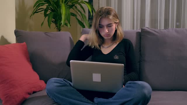 Joven-turca-usando-una-computadora-portátil-mientras-está-sentada-en-el-sofá.