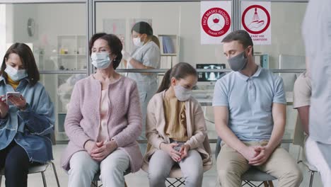 Diverse-Menschen-in-Masken-warten-in-Krankenhaus-Warteschlange