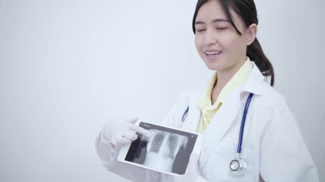 Ärztin-zeigt-und-erklärt-Röntgenfilm-auf-Tablet