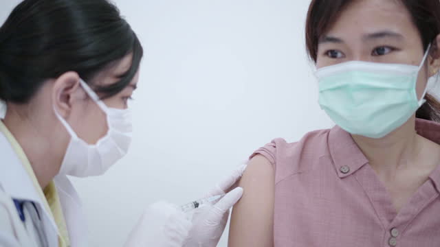 Médico-femenino-vacunando-a-la-paciente-para-prevenir-la-propagación-de-la-enfermedad.