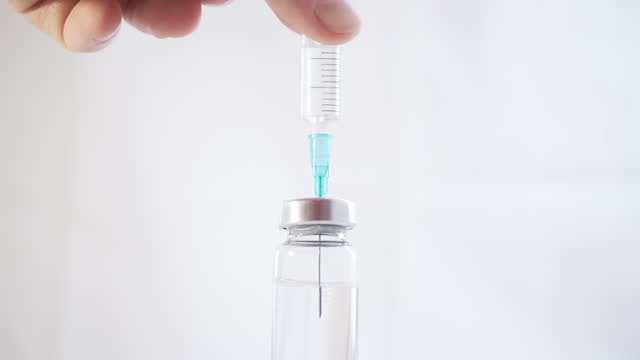 Nahaufnahme-einer-Spritze-mit-einer-Nadel,-die-ein-Medikament-aus-einer-Glasflasche-zeichnet