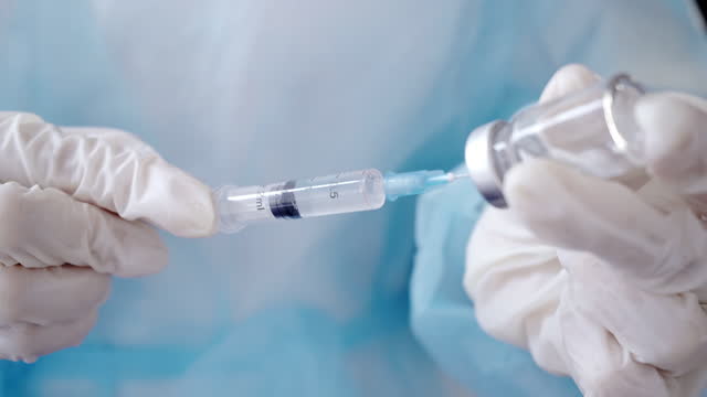 Close-up-of-Hands-in-Medical-Gloves-Filling-a-Syringe-with-Medication