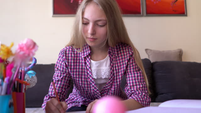 Chica-escribiendo-su-tarea-en-casa