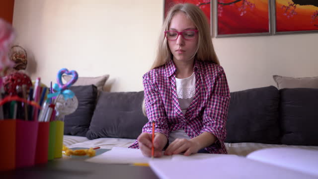 Mädchen-schreiben-ihre-Hausaufgaben-zu-Hause