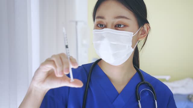 Primer-plano-de-la-doctora-asiática-que-sostiene-una-aguja-de-inyección-de-vacuna-lista-para-la-vacunación.-Jóvenes-técnicos-de-laboratorio-médico-en-el-trabajo