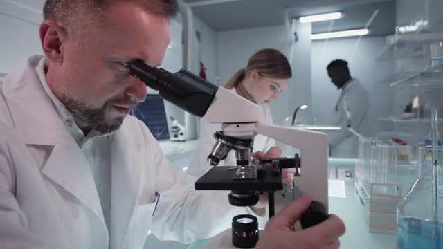 Diverse-scientists-studying-medical-samples.-Using-computers-and-microscopes.-Modern-laboratory-interior