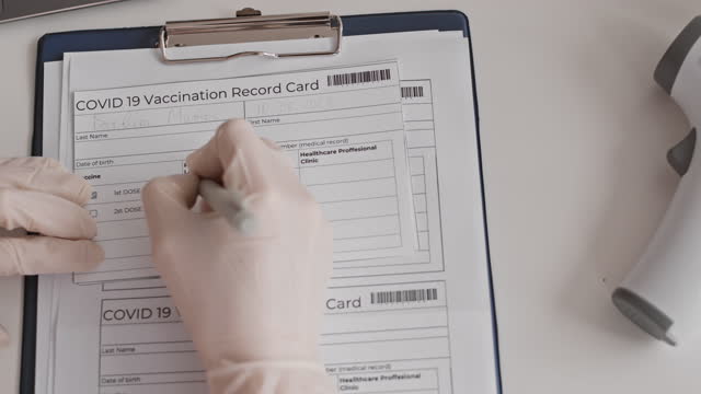 Hand-Filling-in-Vaccination-Record-Card