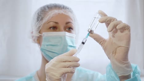 La-doctora-extrae-la-vacuna-del-biberón-a-la-jeringa.-Vacunación-contra-el-coronavirus