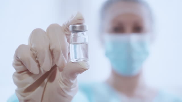 Frau-Arzt-in-medizinische-Reinheit-hält-Glas-Vial-Impfstoff
