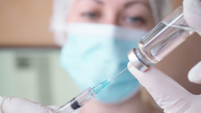 Female-doctor-draws-vaccine-from-bottle-into-syringe.-Coronavirus-vaccination