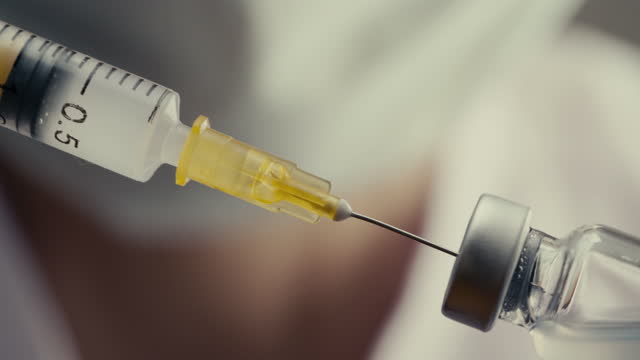 Médico-llena-jeringa-con-vacuna