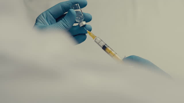 Doctor-filling-syringe-with-vaccine