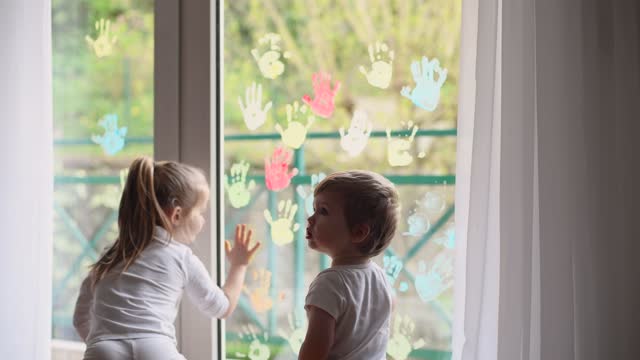 Kinder-malen-mit-Palmen-auf-das-Fenster.-Quarantäne