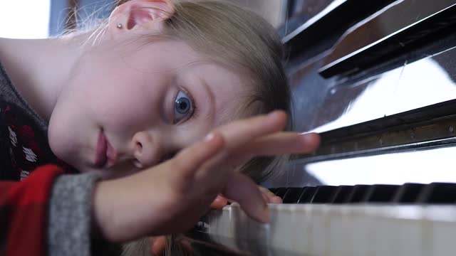 Atractivo-niño-estudia-melodía-musical-en-lección-de-piano