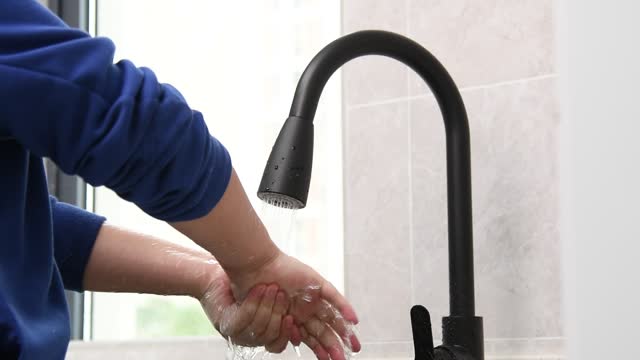 Zeitlupenvideo-von-Jungen,-der-Hände-unter-fließendem-Wasser-wäscht