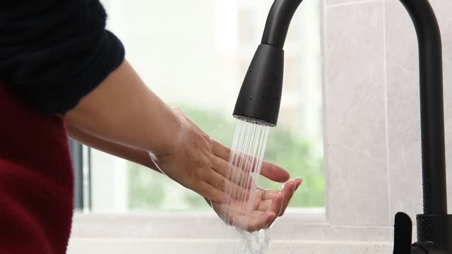 Vídeo-a-cámara-lenta-de-una-mujer-lavándose-las-manos-bajo-el-agua-corriente