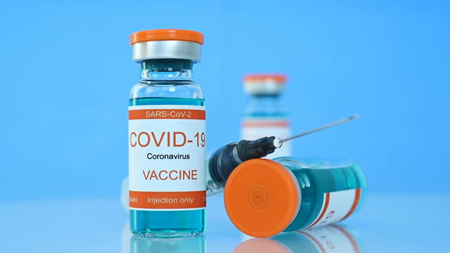 Glass-Bottles-With-Covid-19-Vaccine-And-Syringe-Injection.