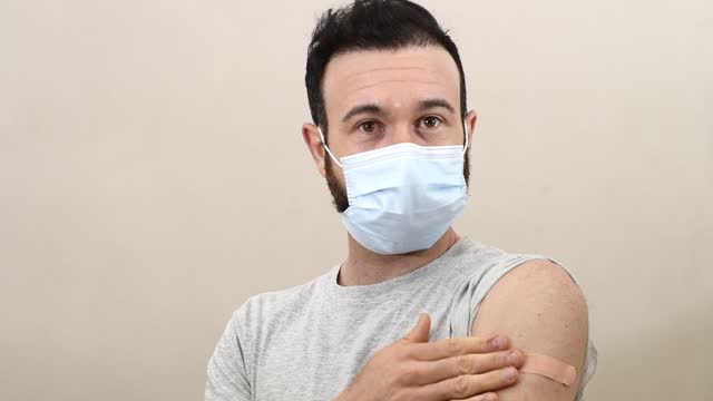 kaukasischer-Mann-impfen-zeigen-seine-Band-Hilfe-auf-seinem-Arm