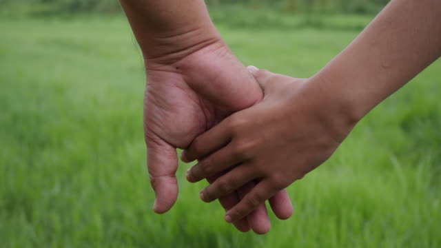 Close-up-hand-of-the-father-holding-the-daughter-hand-in-slow-motion-scene