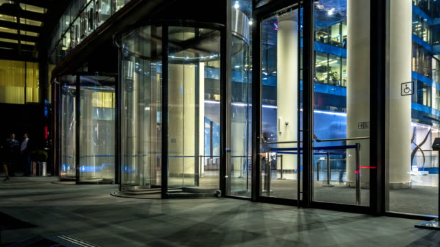 the-flow-of-people-passing-through-the-revolving-door-of-the-modern-office-building-at-the-end-of-the-working-day,time-lapse